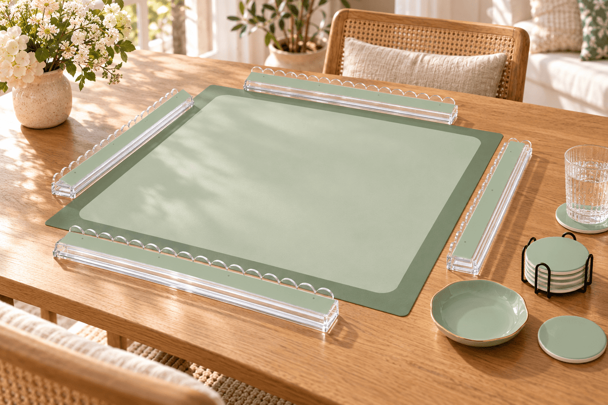 SOFT SAGE mahjong mat with sage green acrylic racks, a ceramic dice tray and ceramic coasters displayed on a sunlit oak table.